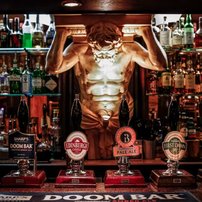 Cask ale taps and the gilded Hercules figure behind the bar at The Hercules Pillars, Holborn