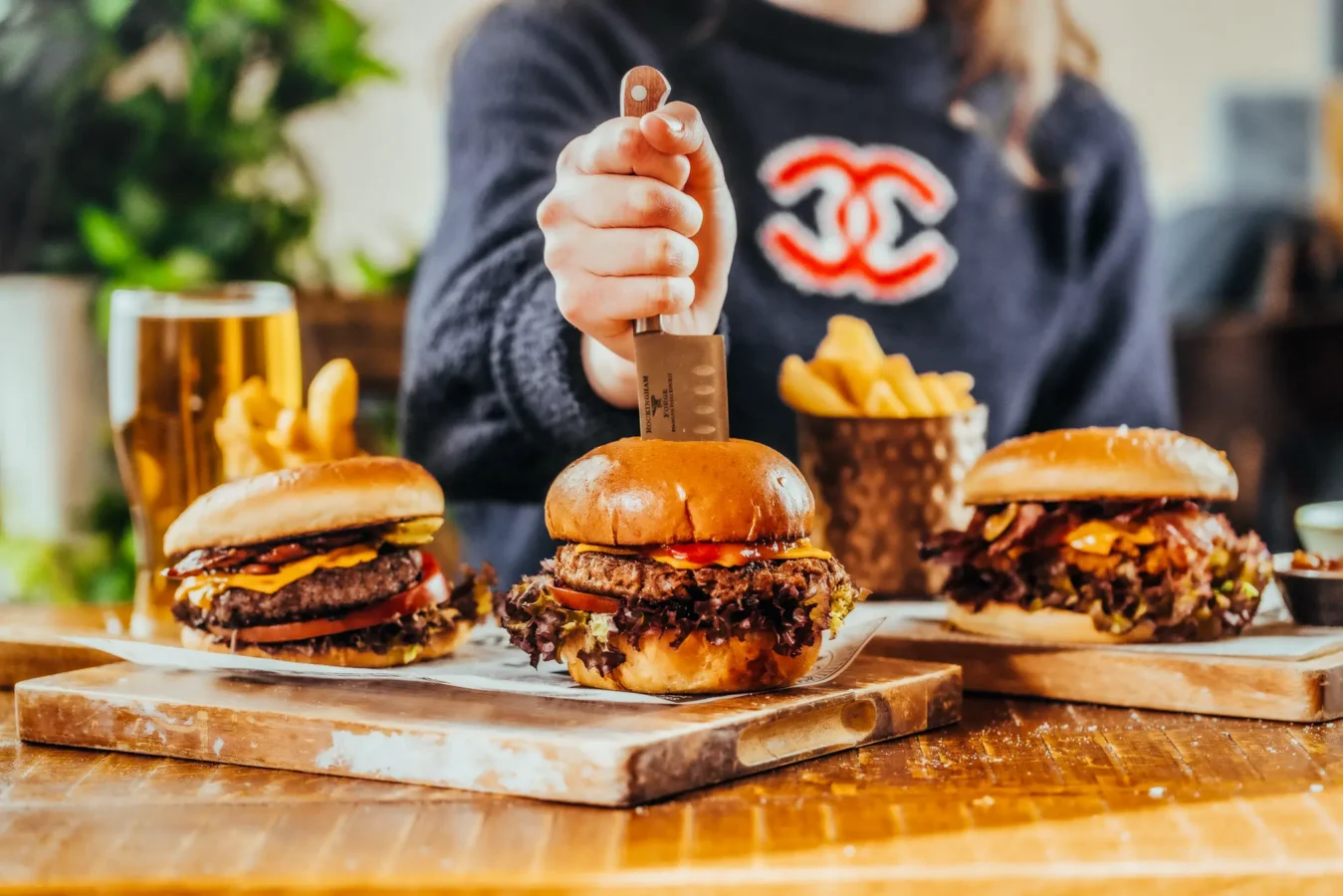 Selection of burgers on a wooden board with fries at The Hercules Pillars, a pub near Holborn station