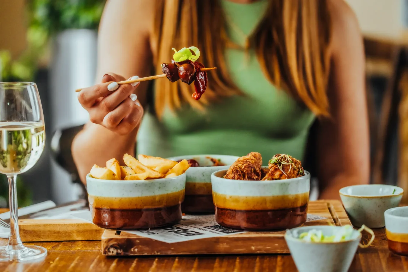 Sharing plates of chicken wings and chips with a glass of white wine at The Hercules Pillars, Holborn