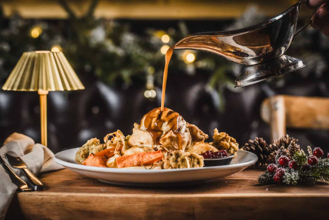 Festive dessert with ice cream, caramel sauce, and cookies on a holiday table.