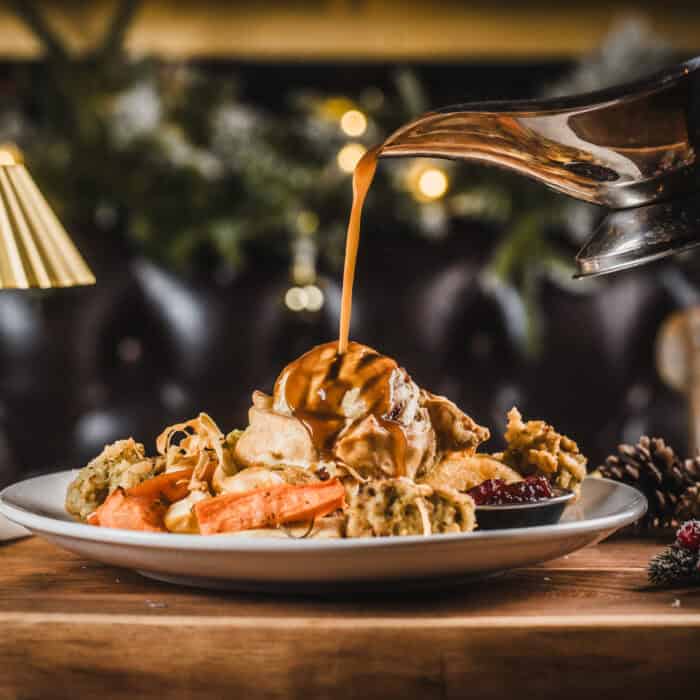 Festive dessert with ice cream, caramel sauce, and cookies on a holiday table.