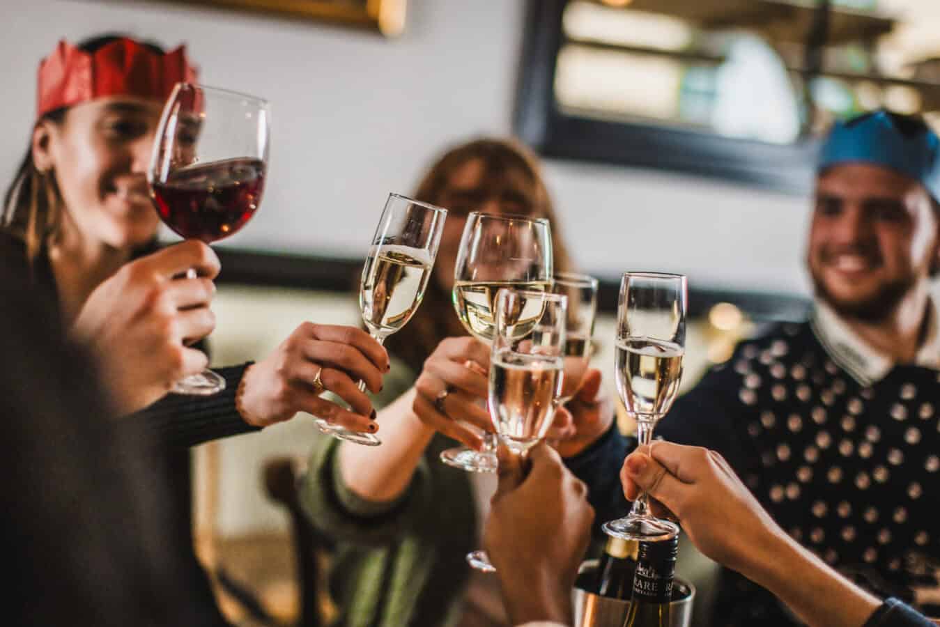 People celebrating with wine glasses in a lively setting.