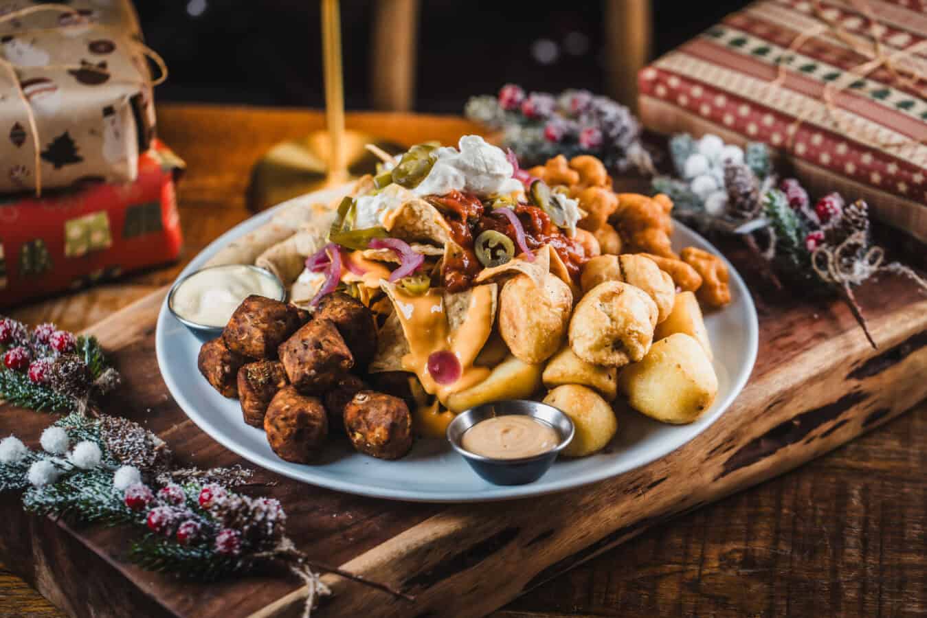 Festive platter with cheese, meats, and snacks for holiday celebration.