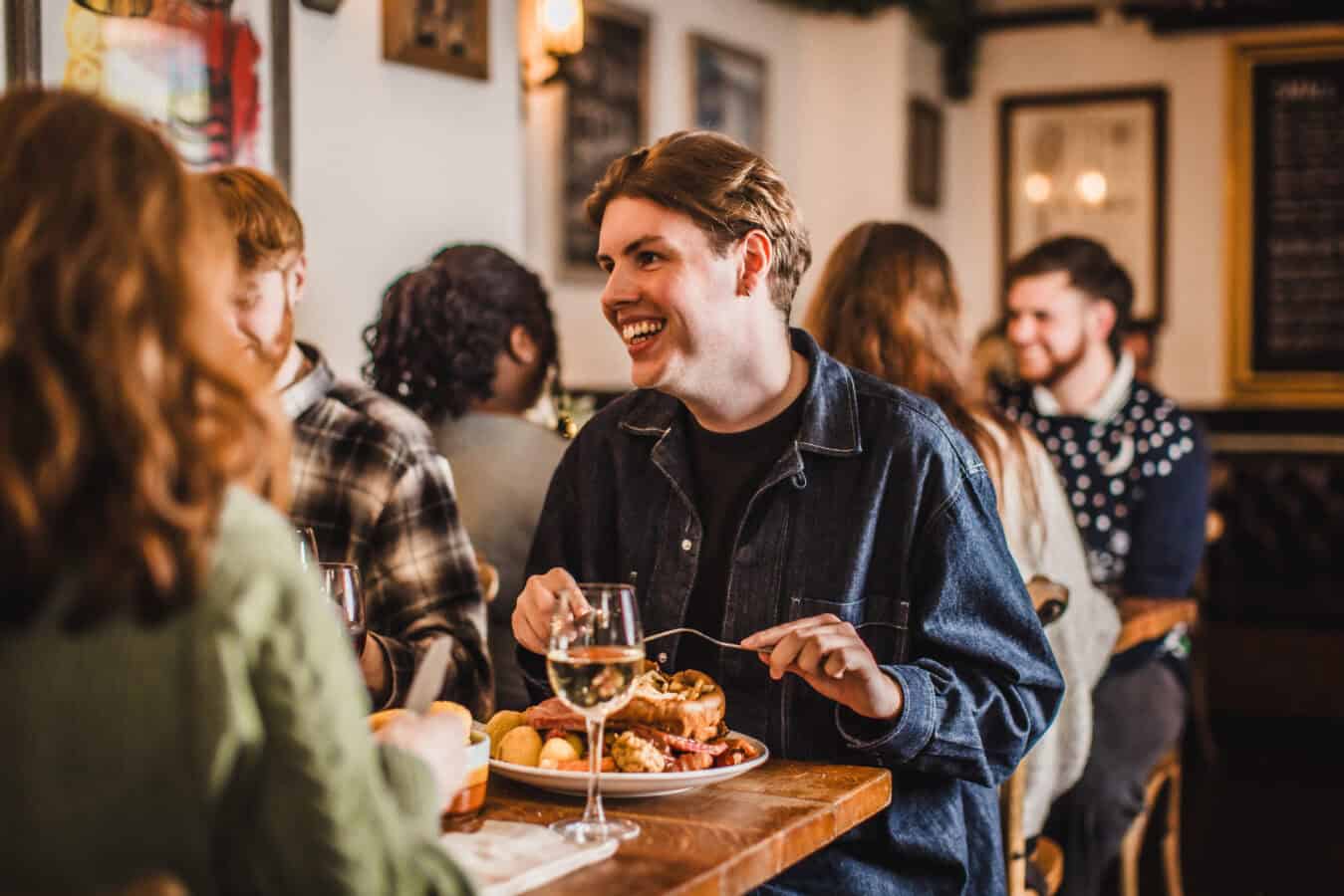 People enjoying a social dining experience at The Hercules Pillars pub.