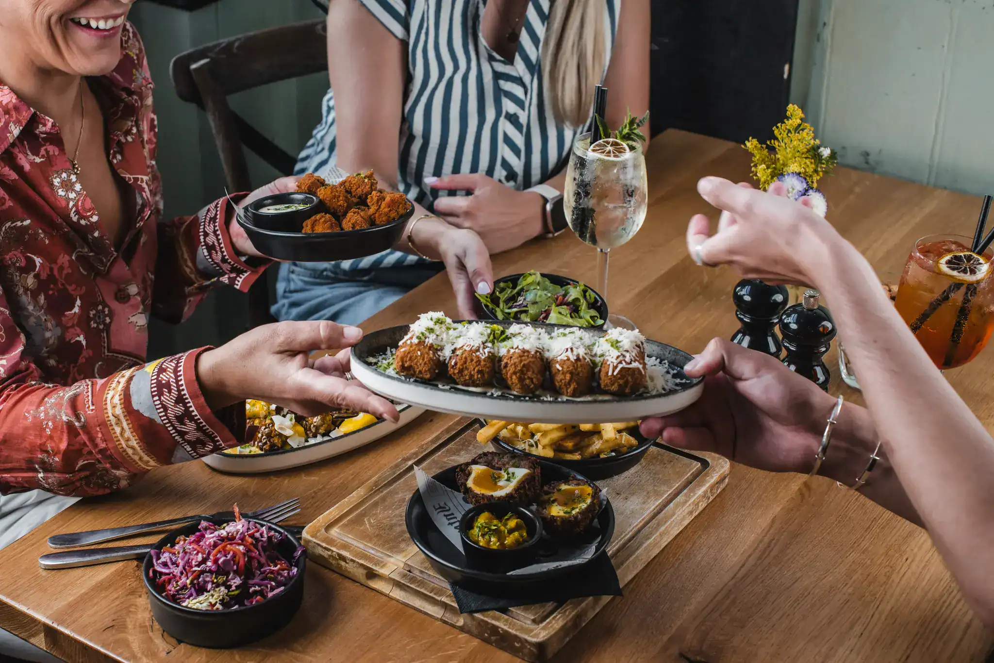 People sharing a variety of dishes at a restaurant table.